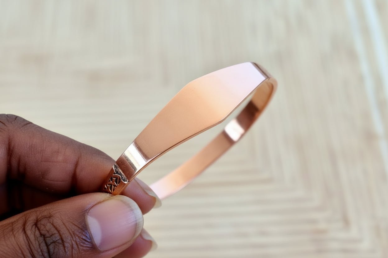 Bracelet Perem Facetté en cuivre tenu à la main, facettes polies qui captent la lumière