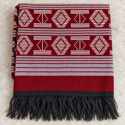 Écharpe Manjak de Luxe rouge pliée, motifs blancs tissés main et franges noires