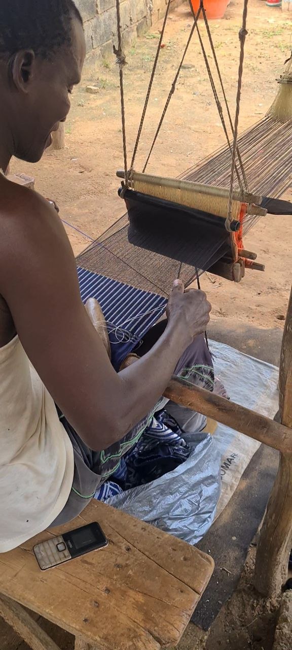 Tisserand Manjak au métier à tisser traditionnel, tissant à la main un pagne Manjak en Afrique