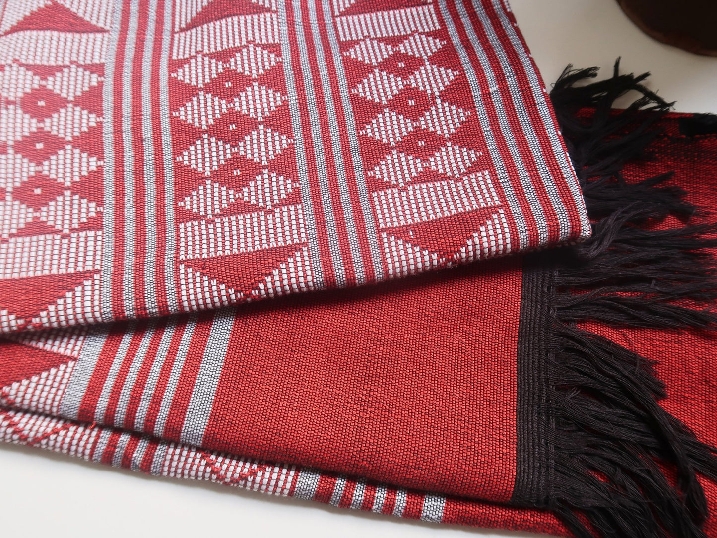 Étole Manjak de luxe rouge profond pliée, détail du tissage et des finitions artisanales, coton naturel Made in Africa