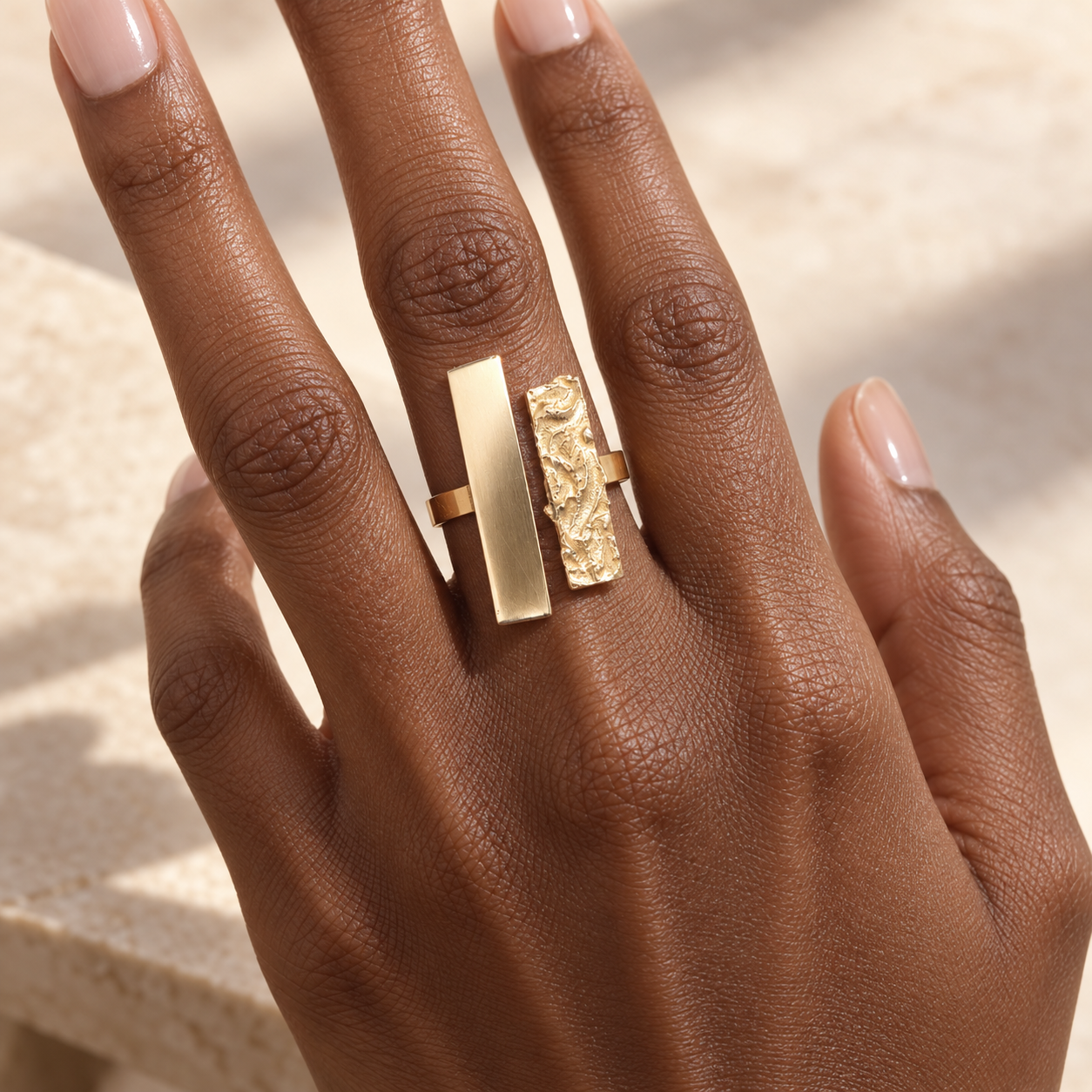 Bague africaine large en bronze doré portée au majeur, à la lumière du jour