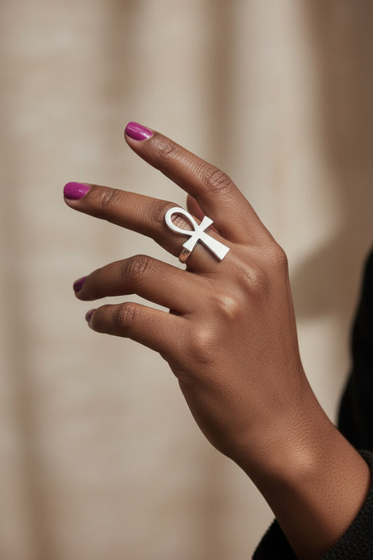 Bague Ankh en argent portée par une main de femme dark skin élégante – bijou africain