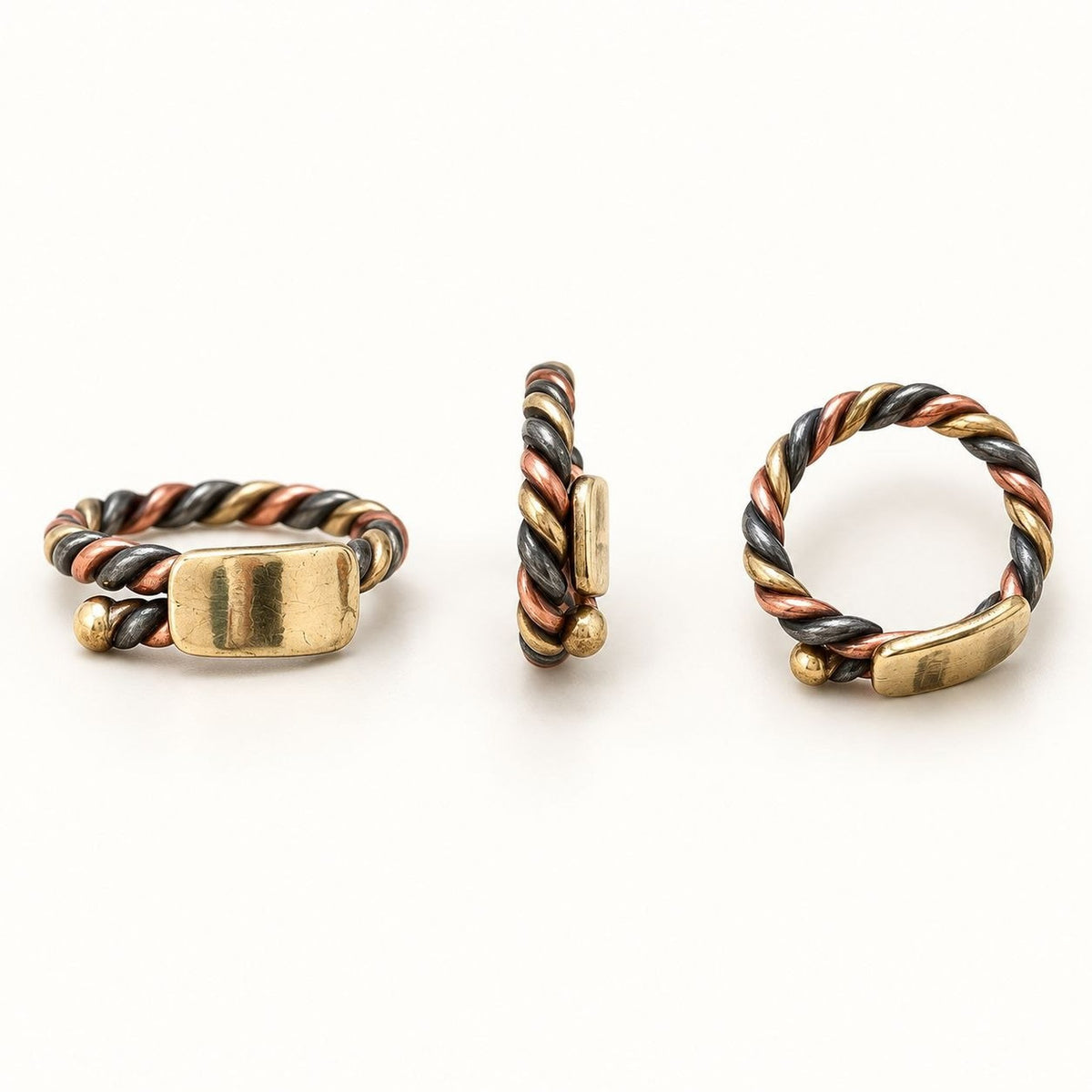Bague sénégalaise Ndiaxass Signature sous trois angles : torsade de cuivre, bronze et fer blanc, plaque en bronze poli, anneau ouvert ajustable