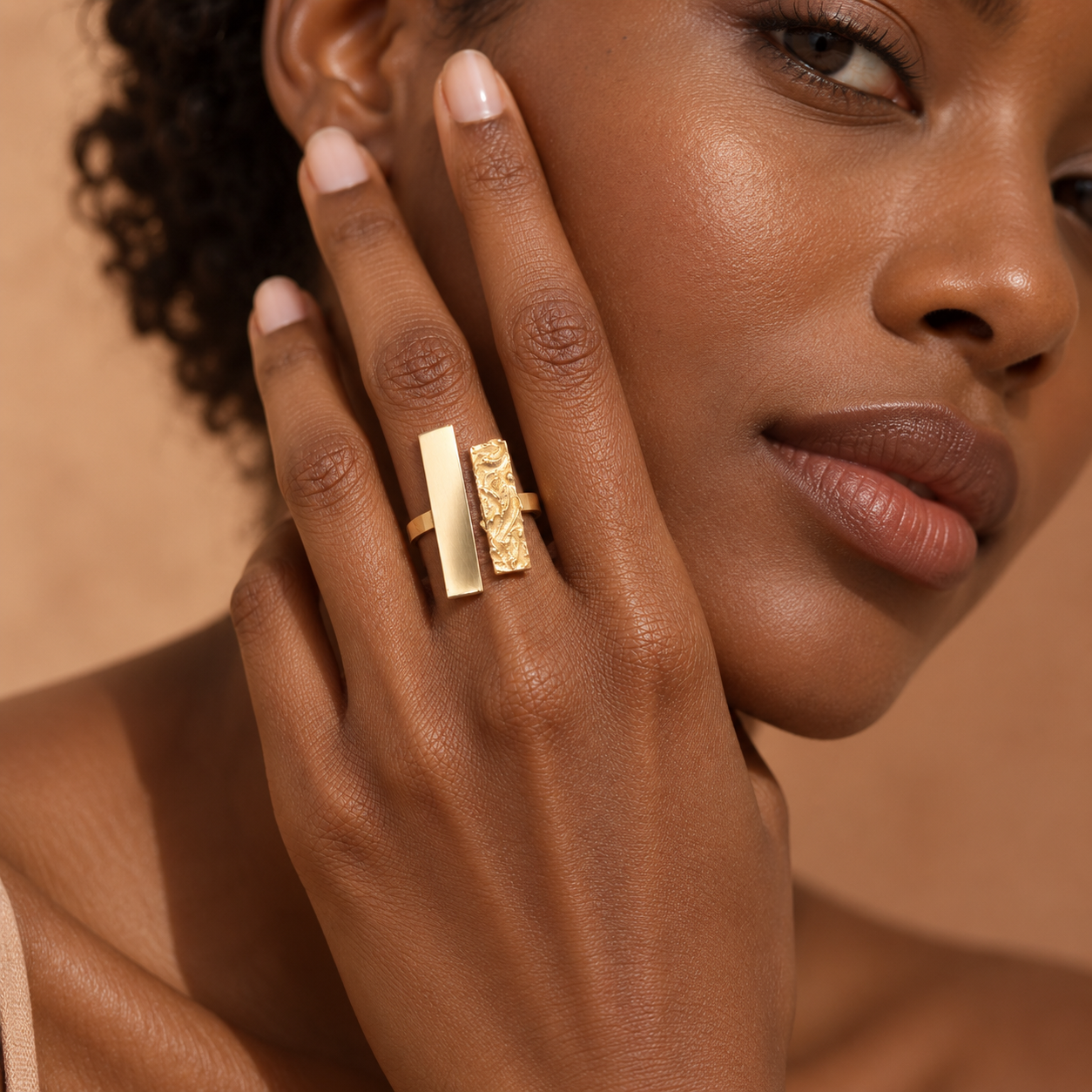 Bijou africain fait main au Sénégal, bague dorée portée près du visage