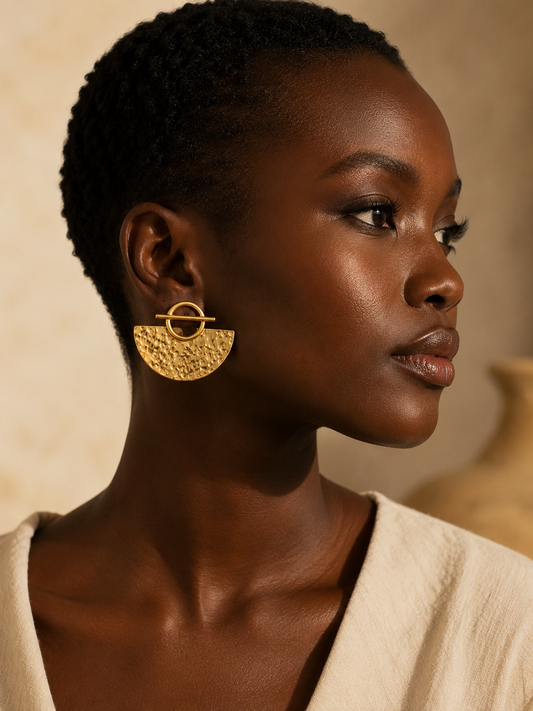 Boucles d'oreilles africaines FOLÓLO en bronze doré portées par une femme noire élégante – bijou artisanal fabriqué à la main au Sénégal par Kaolack Créations