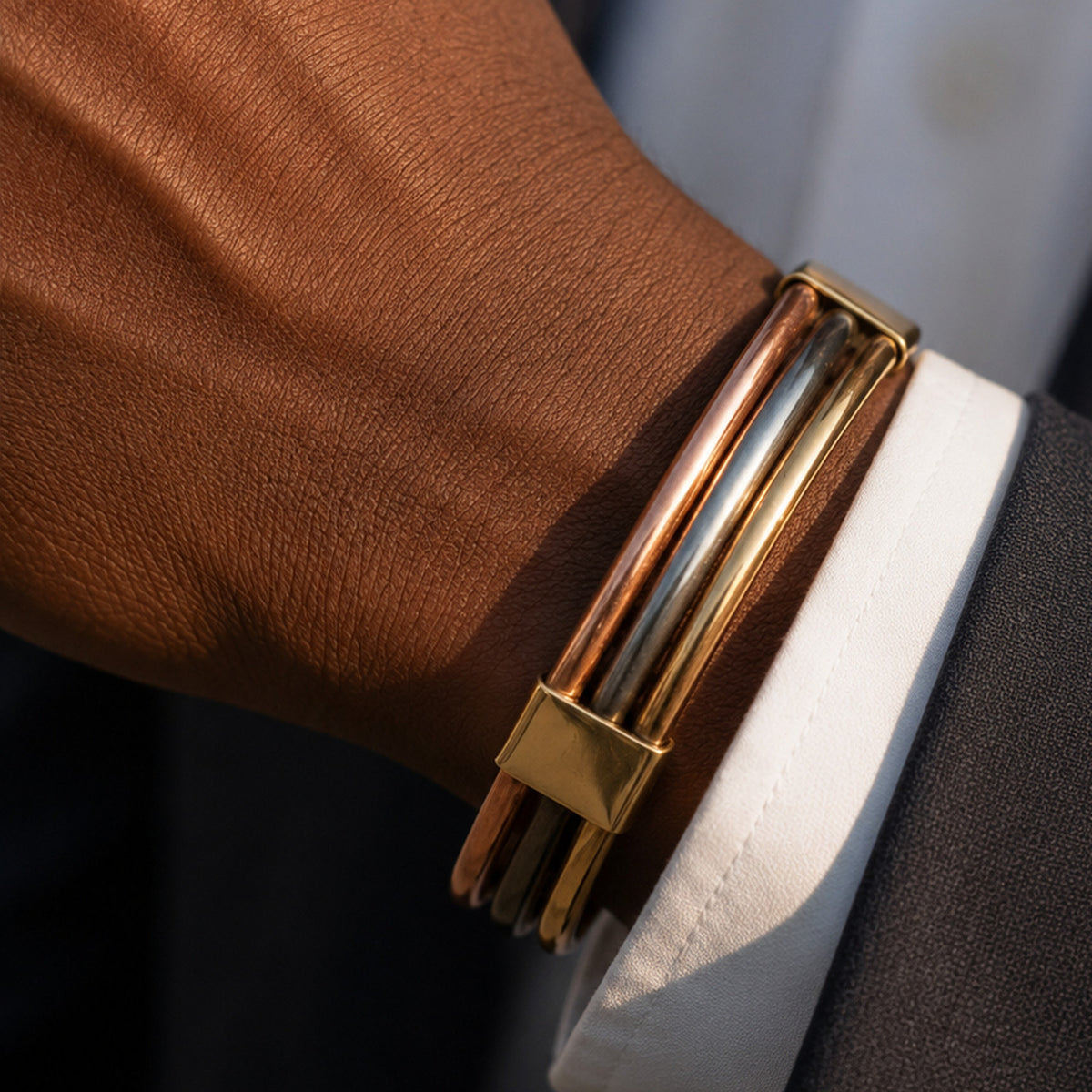 Bracelet Lamou Ndiaxass modèle Ligne droite porté par un homme en costume, sous la manchette