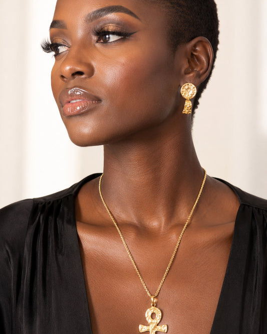 Collier ankh en bronze martelé porté par une femme sur une chemise noire décolletée