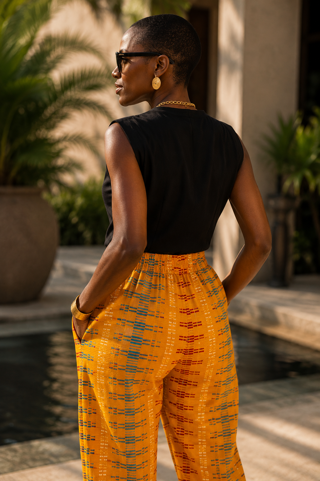 Vue de dos d'un pantalon mixte en véritable pagne Kita Kente Akan, entièrement tissé à la main en coton africain, montrant la taille entièrement élastiquée, la coupe droite, la texture du tissage artisanal et les couleurs vives du textile traditionnel.