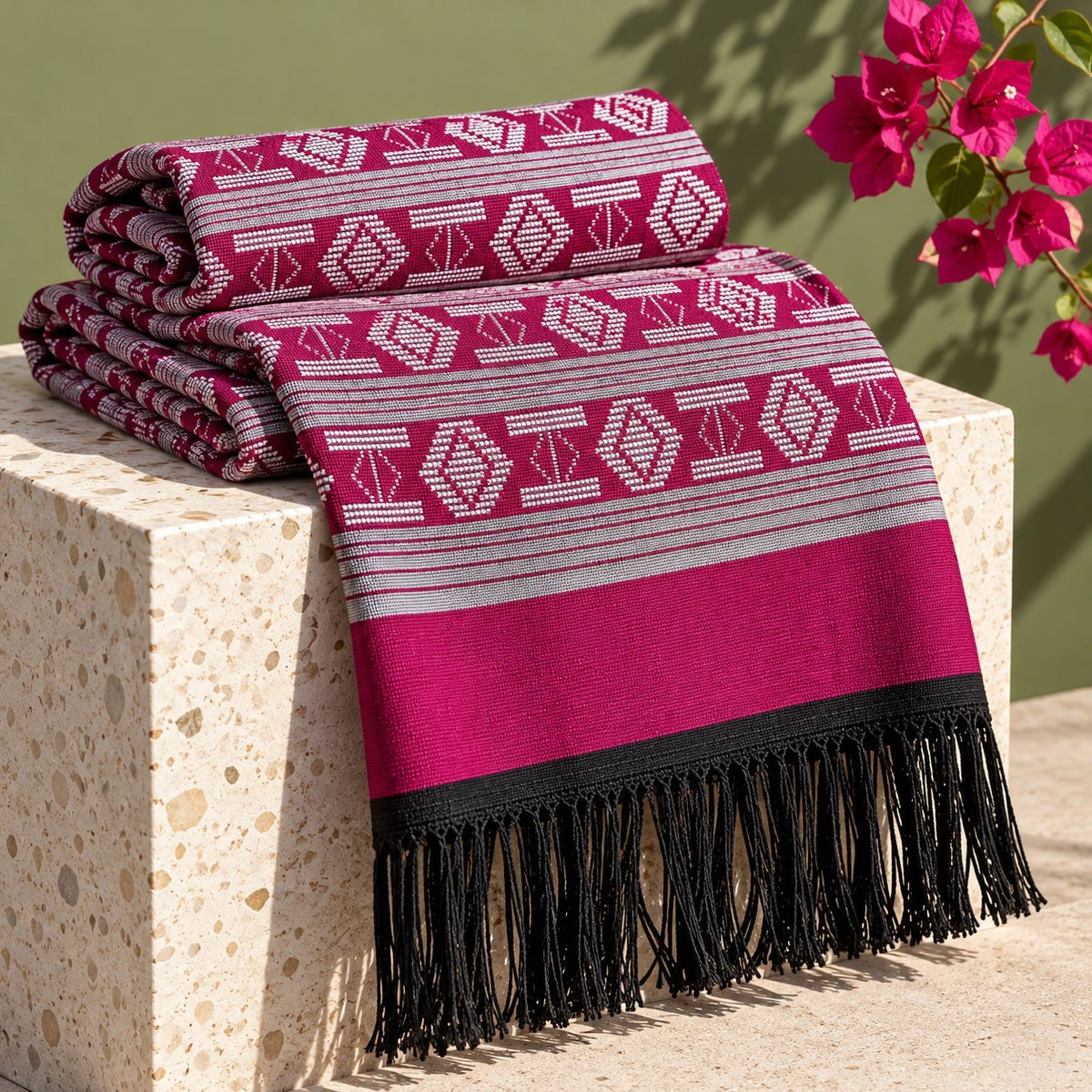 Écharpe-étole Manjak de Luxe fuchsia pliée, motifs blancs tissés main sur toute la longueur, bordure fuchsia et franges noires