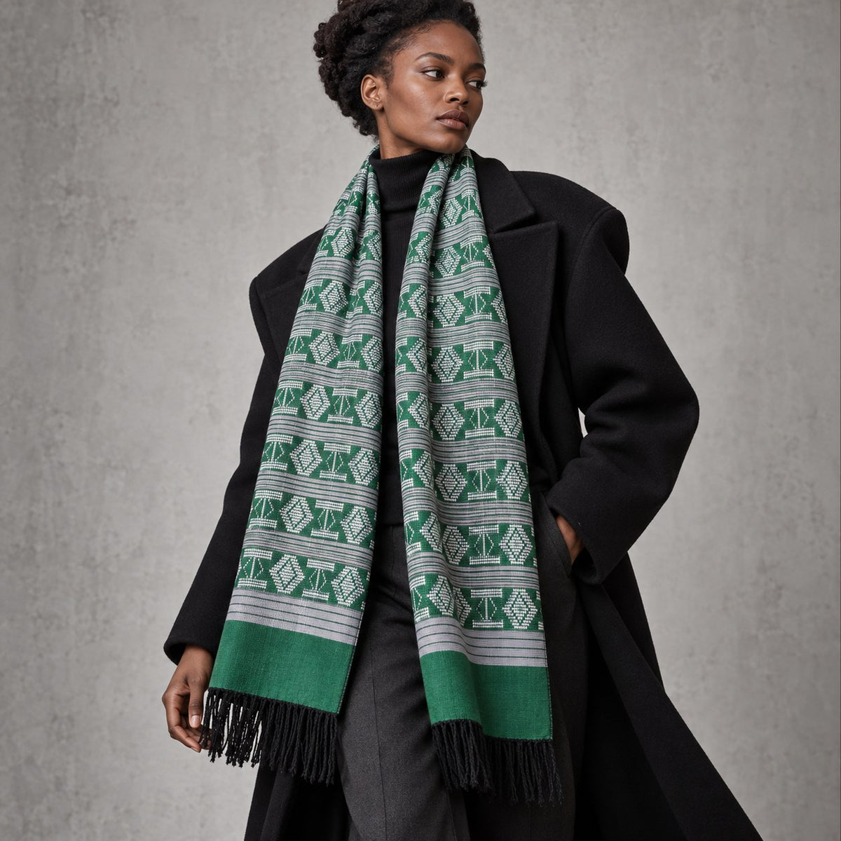 Écharpe-étole Manjak de Luxe verte, motifs blancs et bandes grises, portée par une femme sur un manteau noir