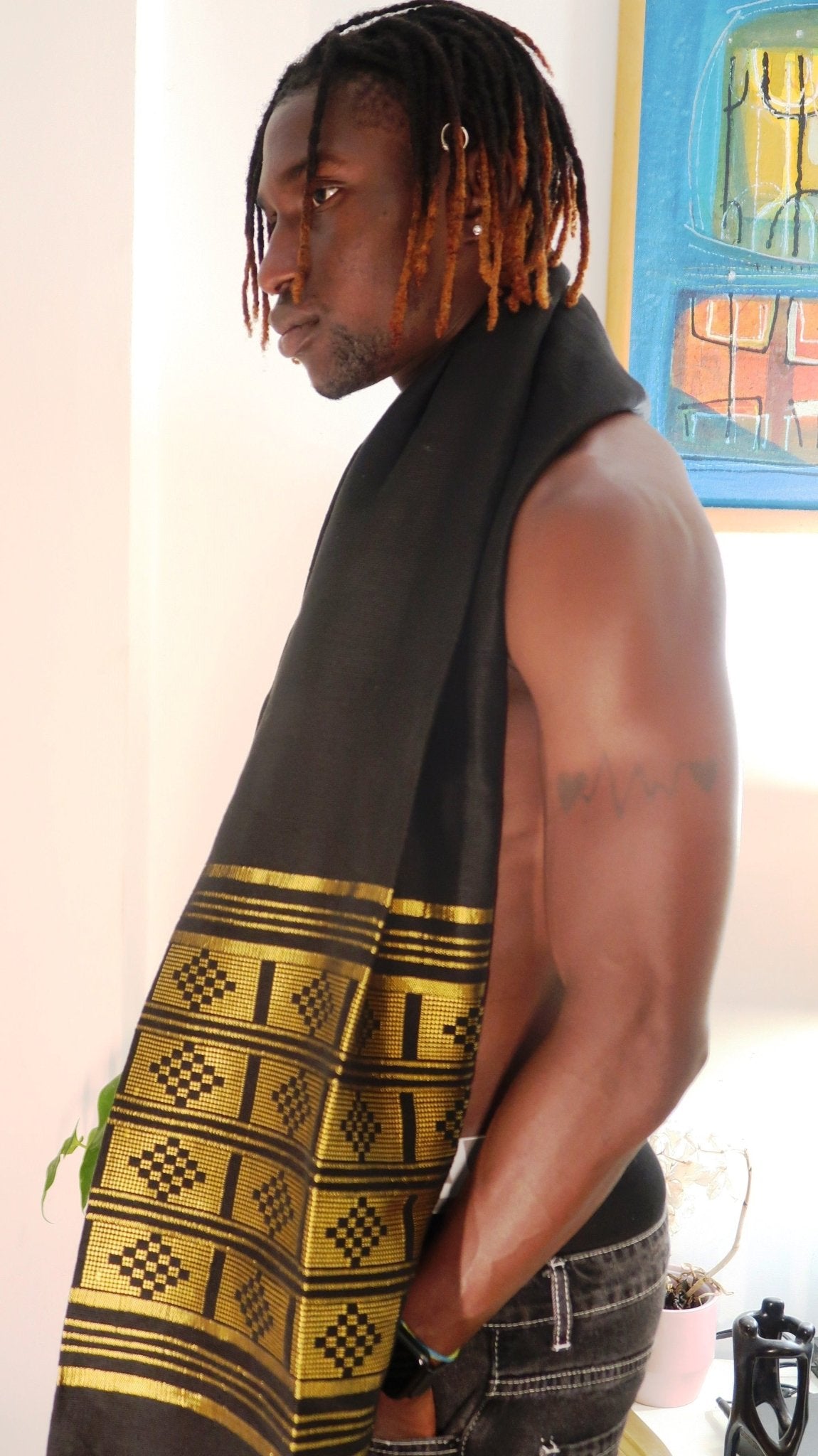 Écharpe-Étole Manjak noire et dorée portée par un homme – pagne tissé africain 100 % coton fait main