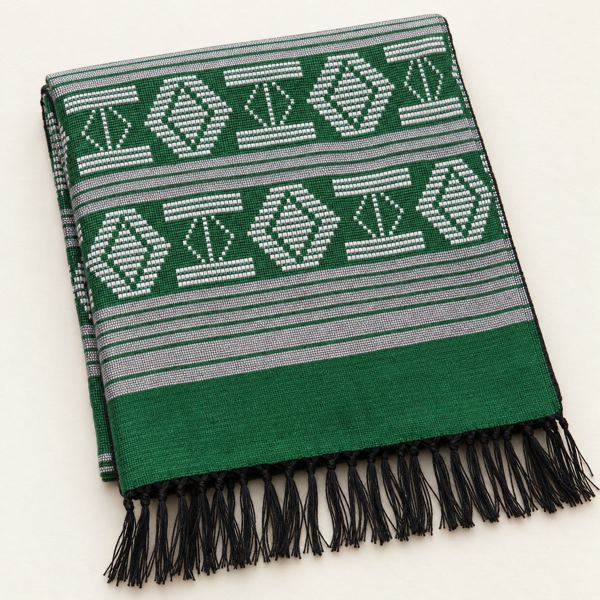 Écharpe Manjak de Luxe verte pliée, motifs blancs tissés main sur toute la longueur et franges noires nouées