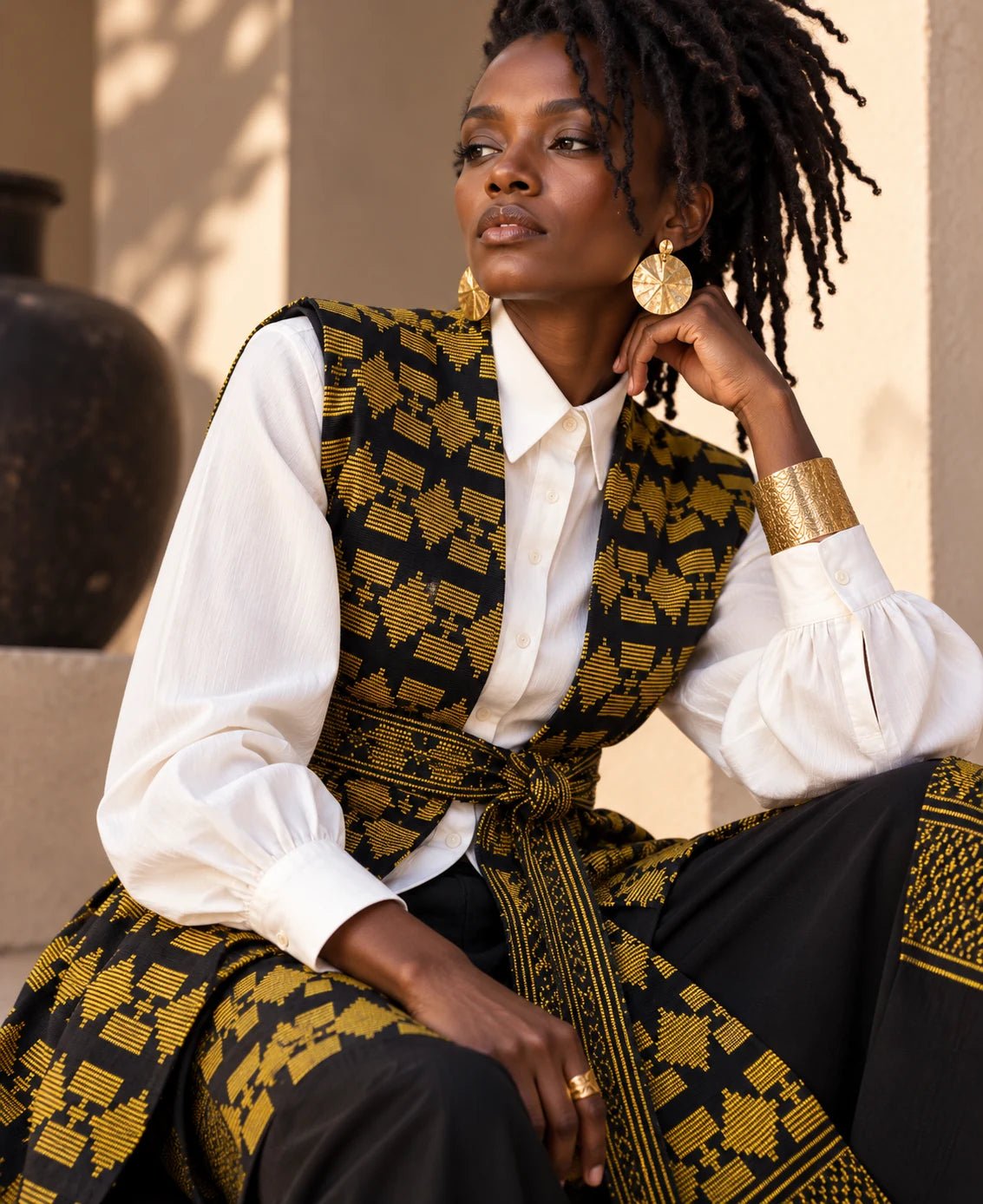 Gilet long mixte en pagne africain tissé main noir et or, femme, sur chemise blanche – Kaolack Créations