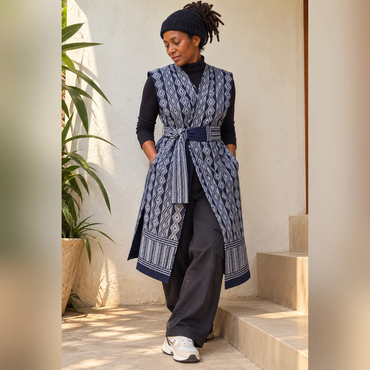 Femme en style streetwear portant le gilet long Manjak bleu marine et gris sur un col roulé