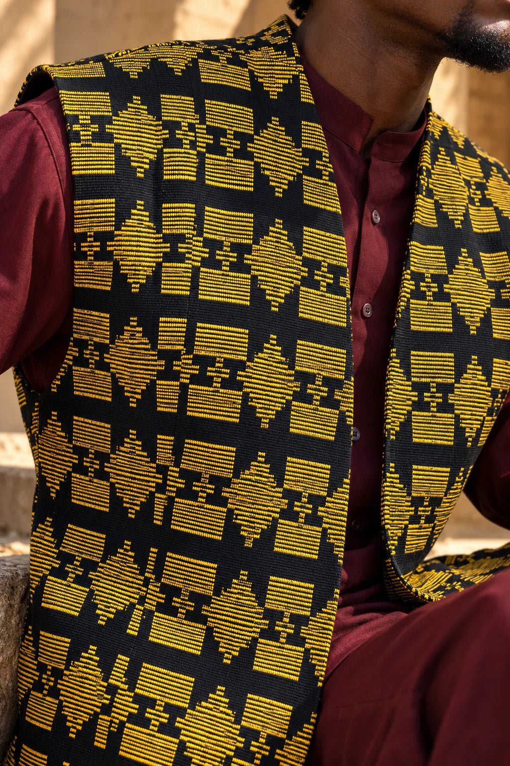 Gilet long mixte en pagne africain tissé main noir et or, détail textile, gros plan du tissage – Kaolack Créations