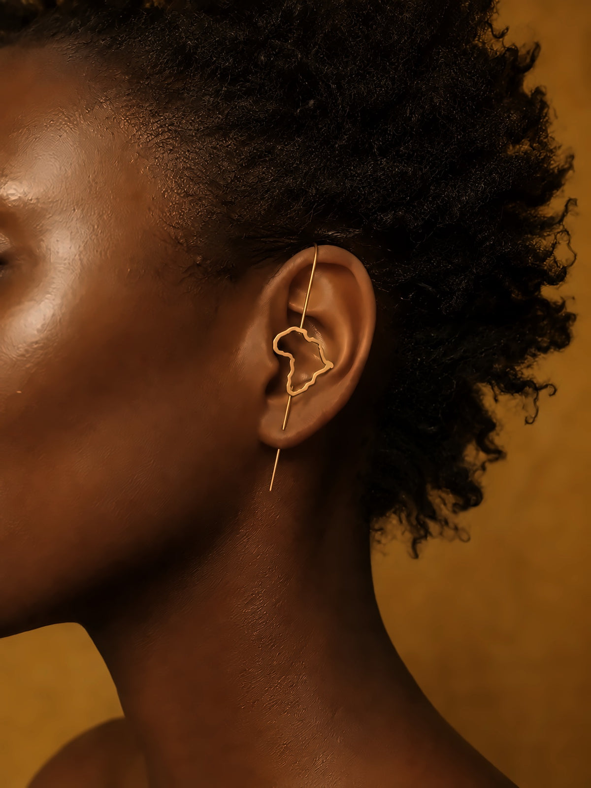 Gros plan de la boucle Kemet sur l'oreille, silhouette du continent africain ajourée