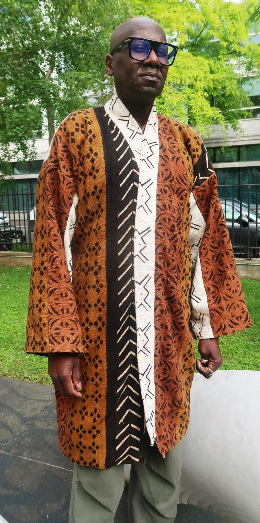Homme portant un manteau kimono en bogolan multicolore – pièce artisanale unique du Mali.