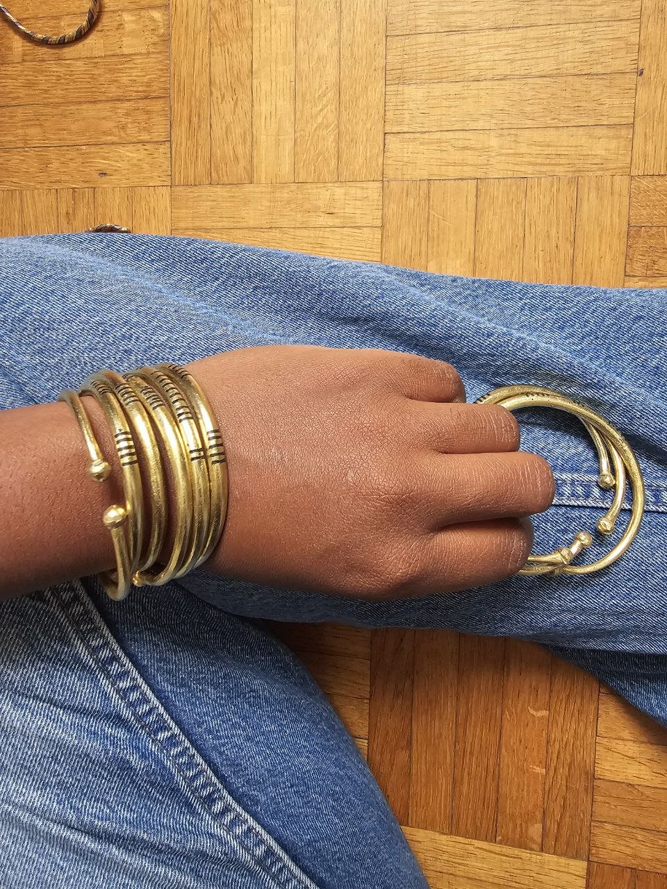 Trois bracelets Yama en bronze portés par une femme – bijoux artisanaux africains