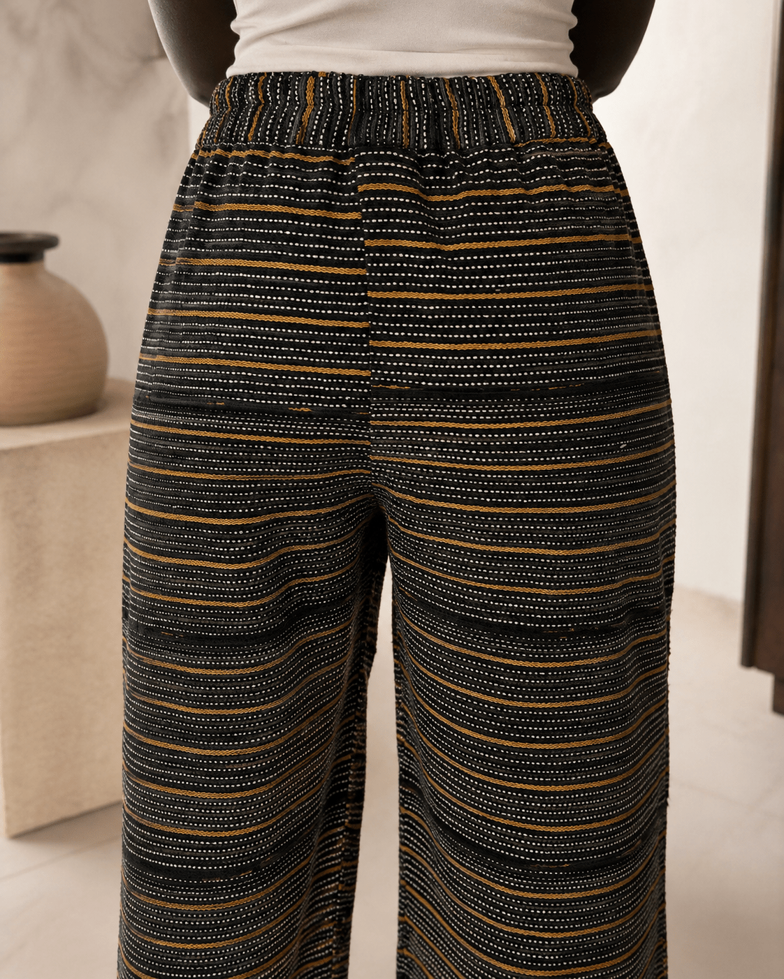 Vue de dos du pantalon Faso Dan Fani : ceinture élastiquée froncée et bandes tissées main assemblées