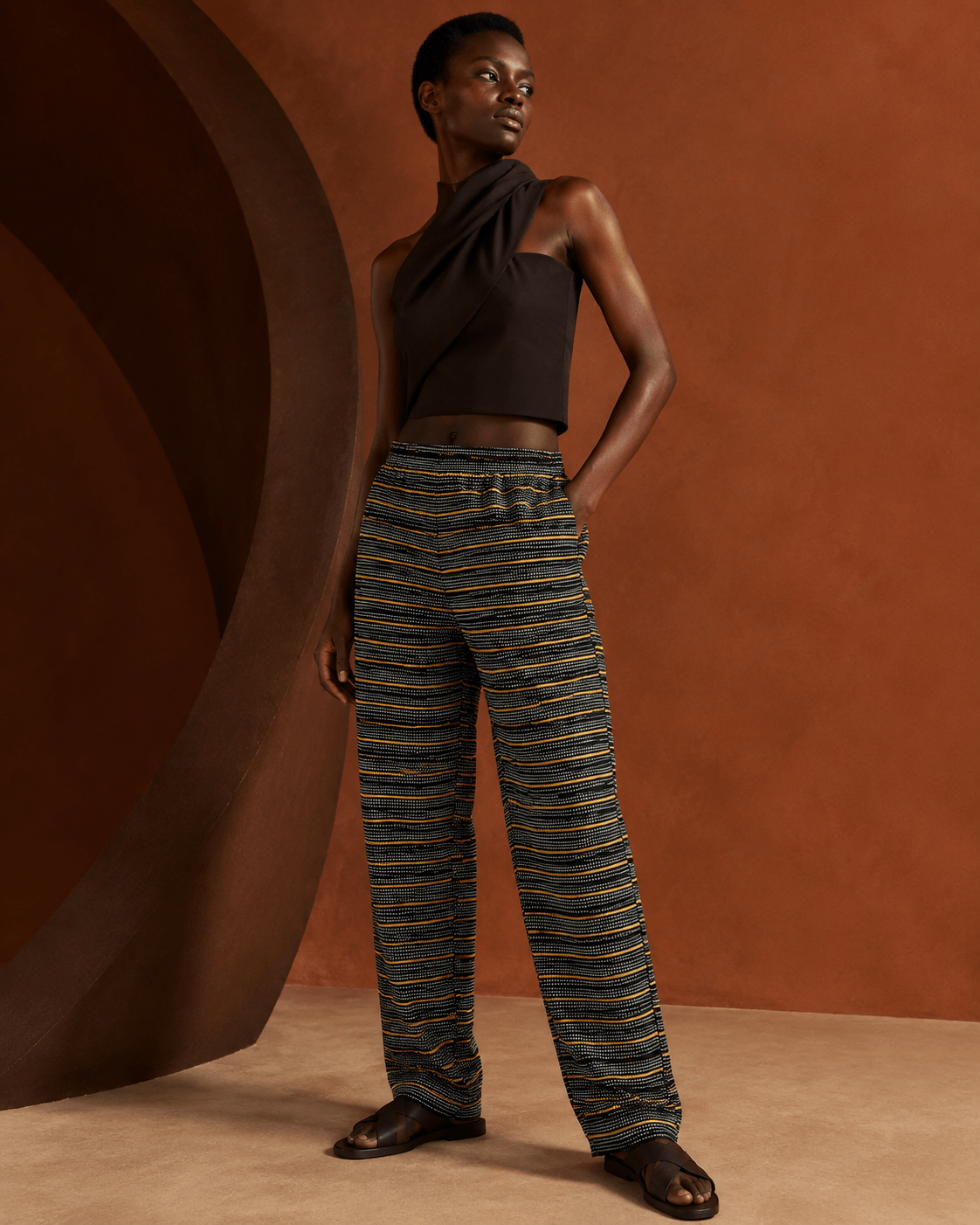 Femme portant le pantalon en Faso Dan Fani noir et ocre, pagne tissé main du Burkina Faso