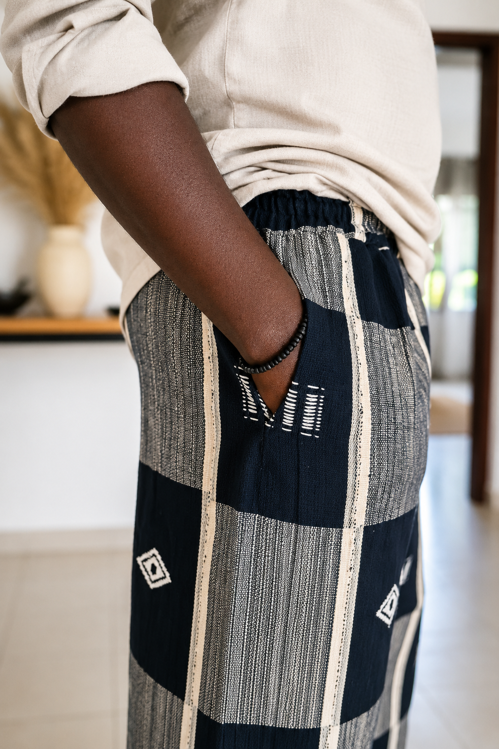 Détail de la poche d'un pantalon en véritable pagne tissé Sénoufo de Korhogo, 100 % coton, mettant en valeur le tissage artisanal et les finitions soignées.