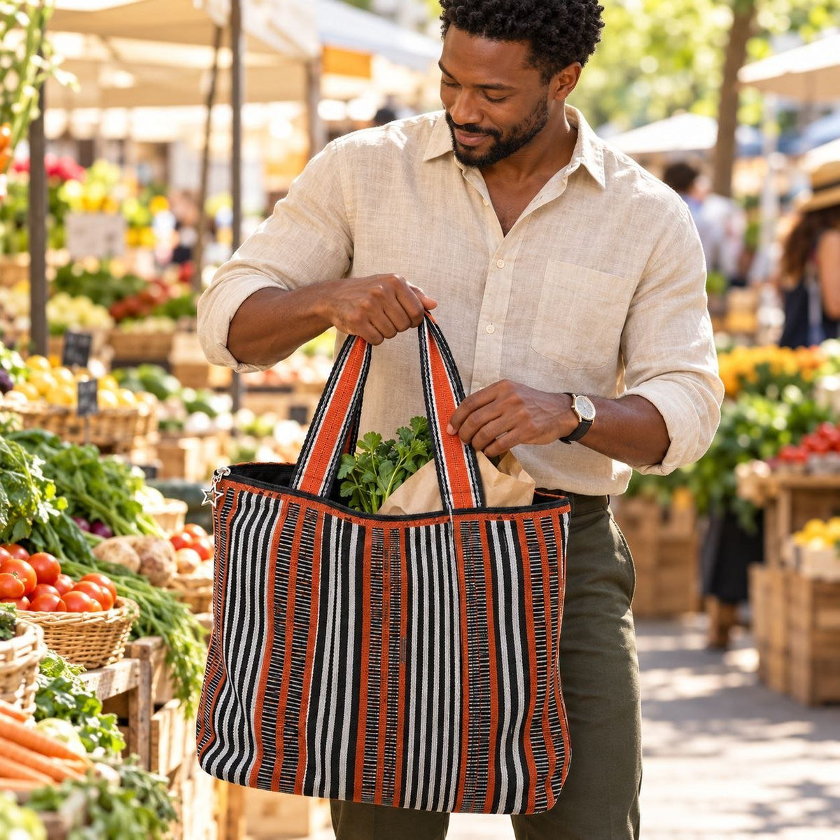 Homme portant le sac shopper LUMA en pagne Sérère au marché, rempli de légumes