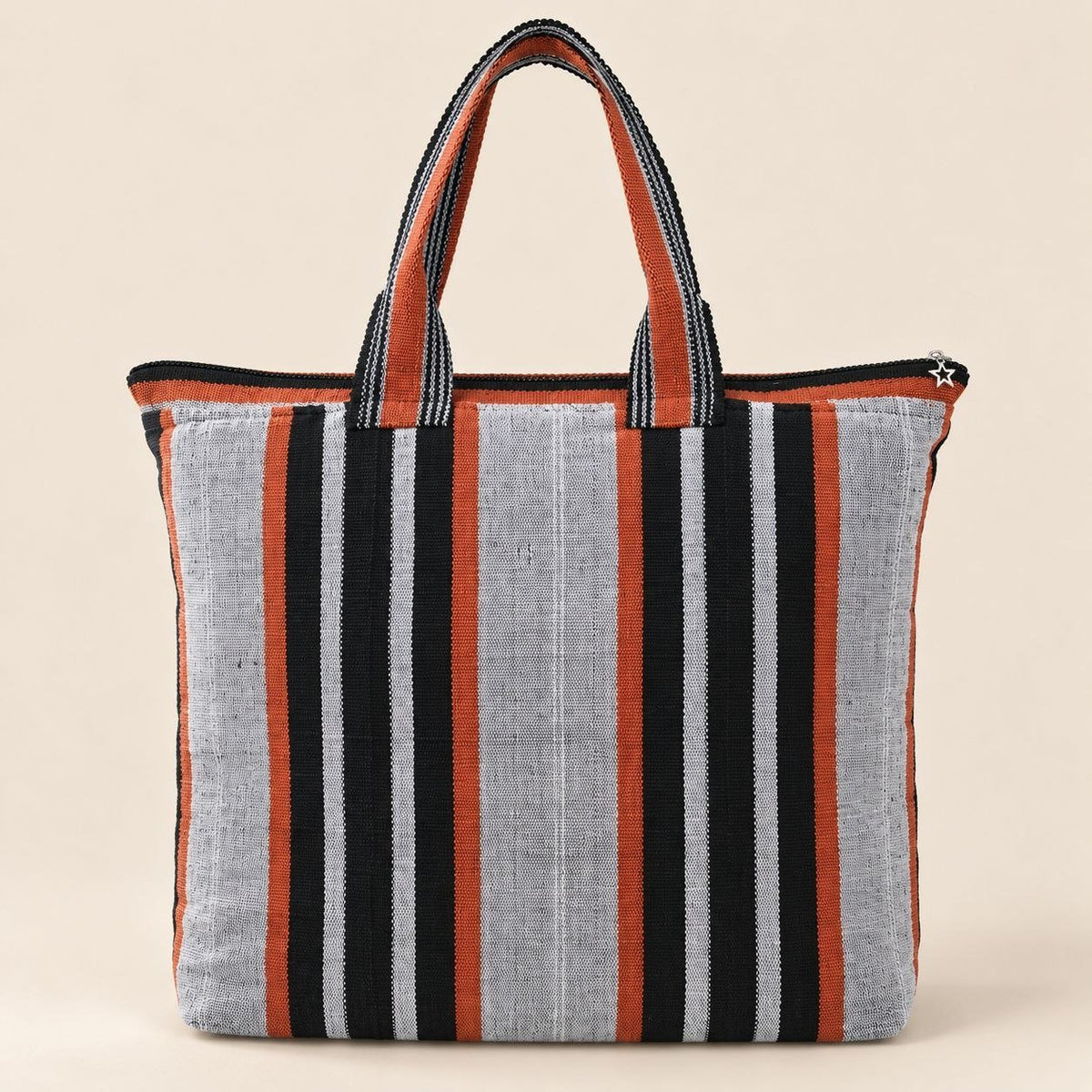 Face verso du sac LUMA, larges bandes noires et orange sur fond gris clair