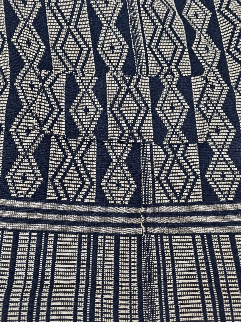 Gros plan du tissage Manjak bleu marine et gris argenté et de la poche de la veste boule – Kaolack Créations