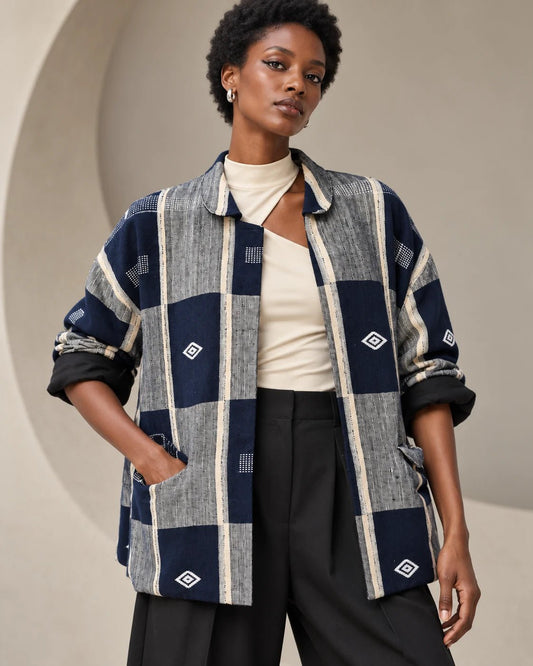 Veste boule Sénoufo bleu marine, gris et écru portée ouverte par une femme, manches retroussées sur la doublure noire.