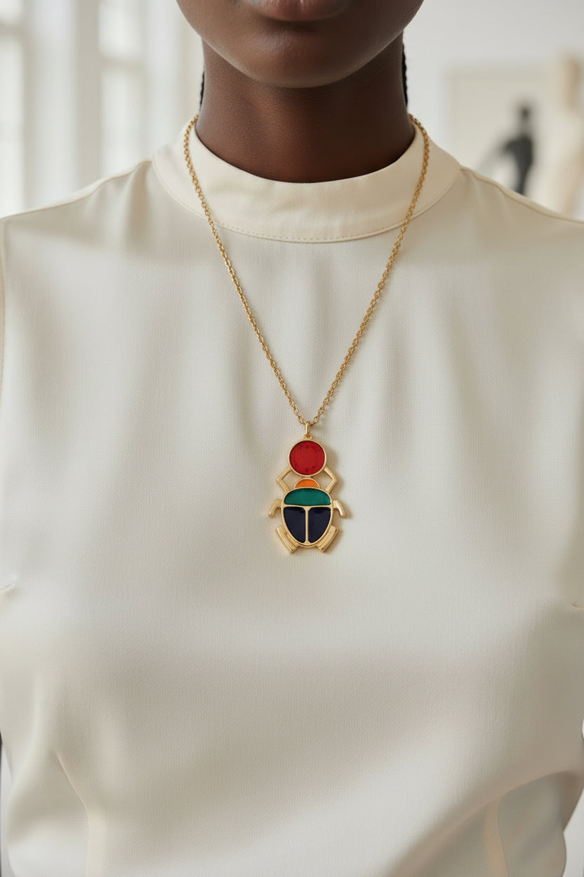 Collier Scarabée Kheper en zamak avec chaîne en acier inoxydable doré porté par une femme africaine – bijou symbolique Kaolack Créations