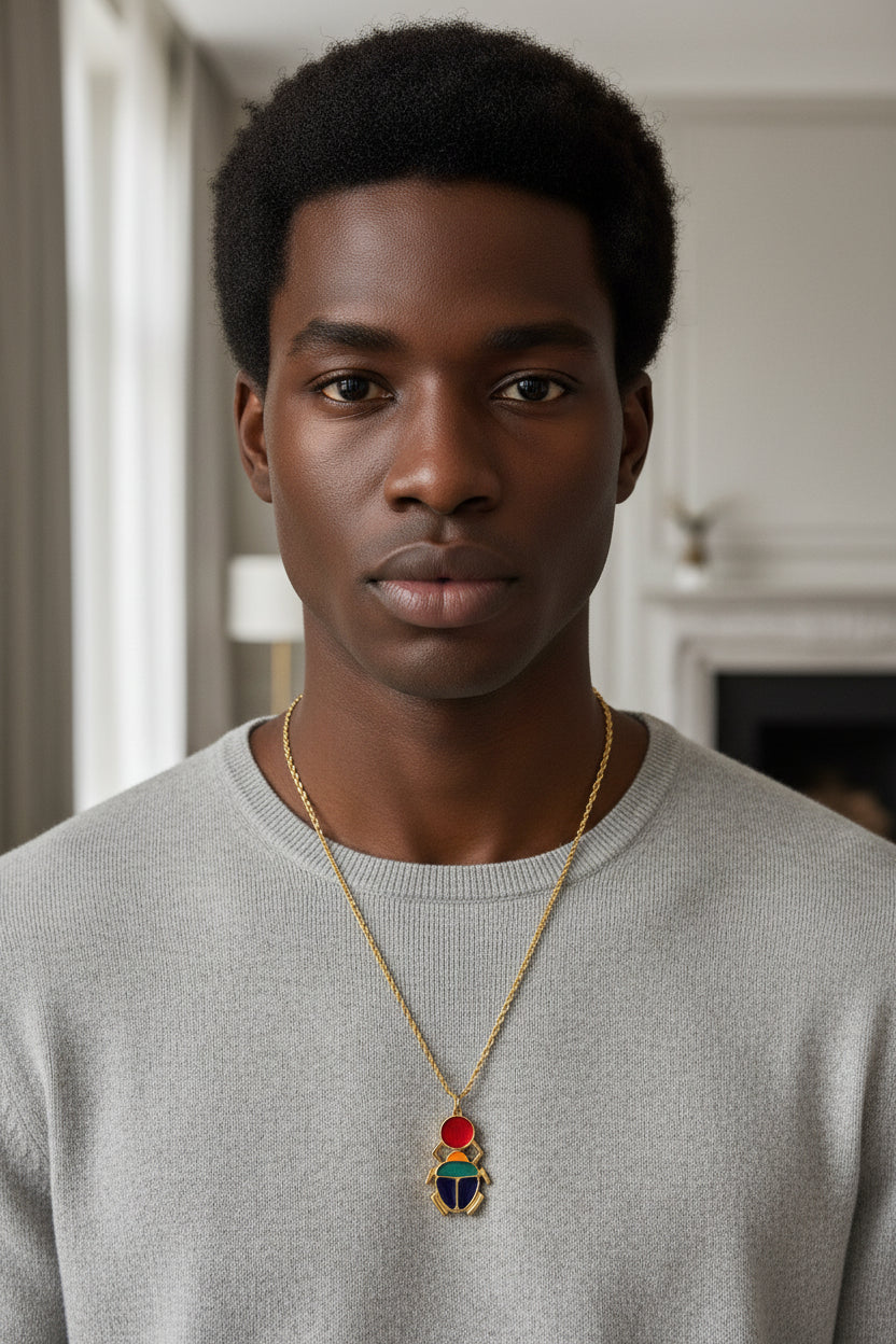 Collier Scarabée Kheper en zamak avec chaîne en acier inoxydable doré 70 cm porté par un homme africain – bijou symbolique Kaolack Créations