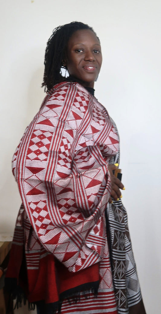 Femme portant une étole Manjak de luxe rouge profond, tissée main en coton artisanal — pagne africain de Casamance, édition très limitée Kaolack Créations
